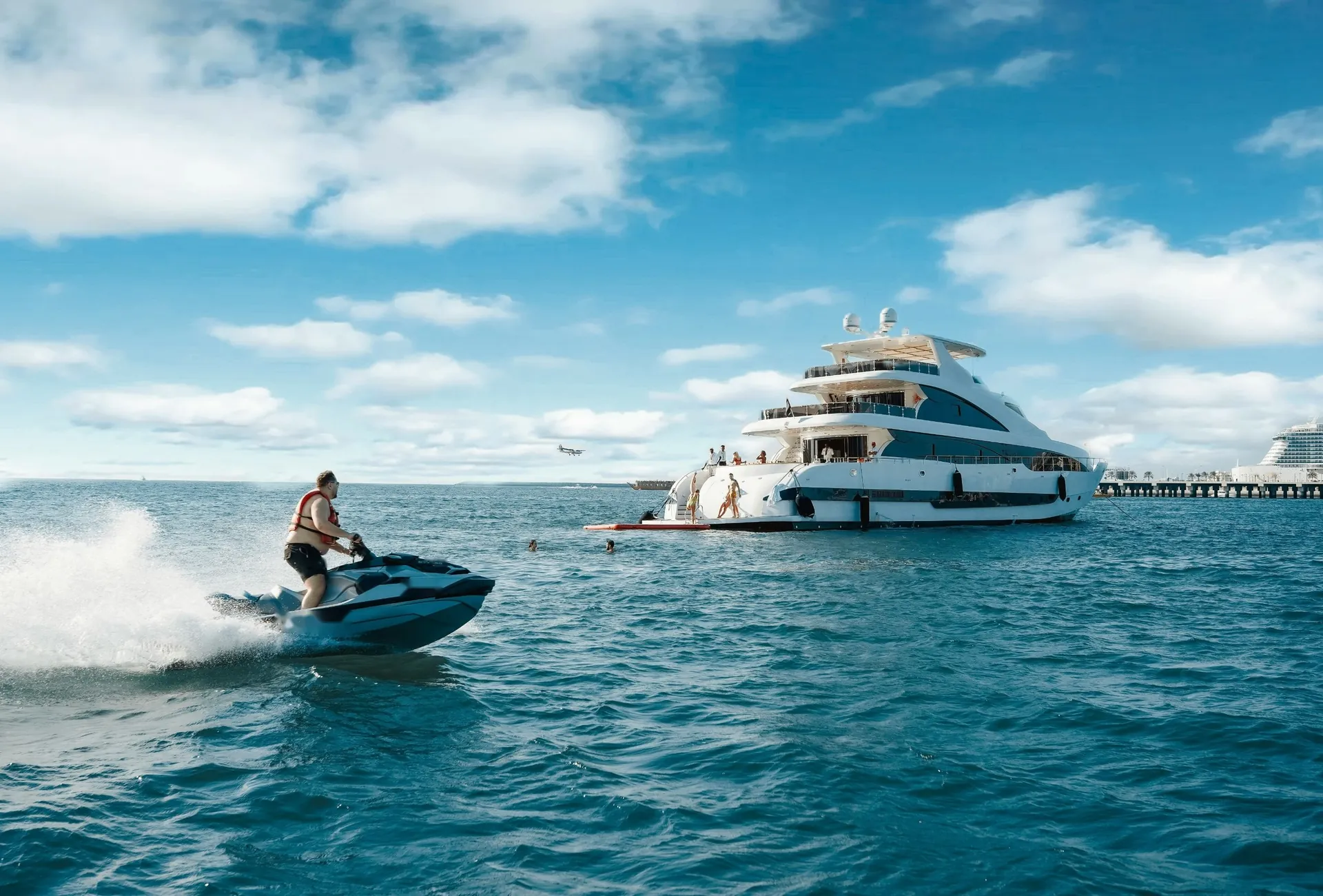Jet ski no mar com um iate ao fundo