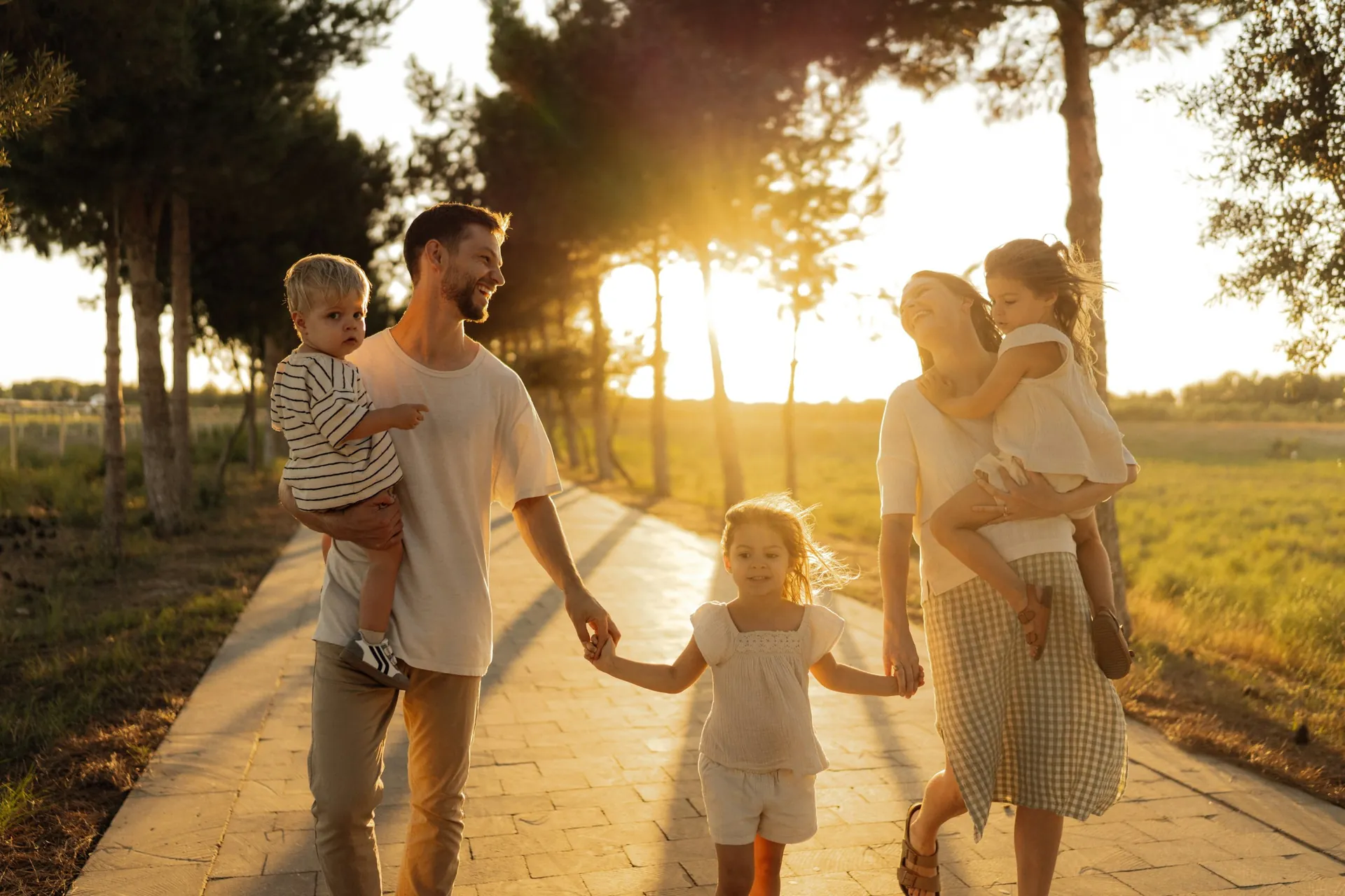 Família caminhando de mãos dadas ao pôr do sol